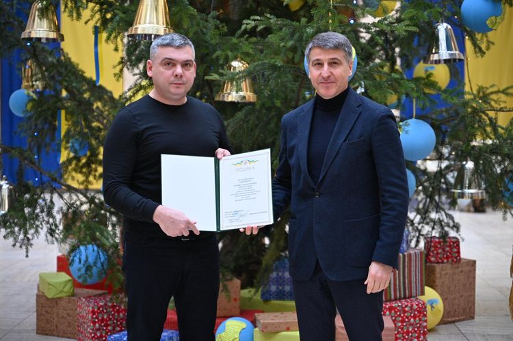 Мирослав Білецький вручає відзнаку волонтеру