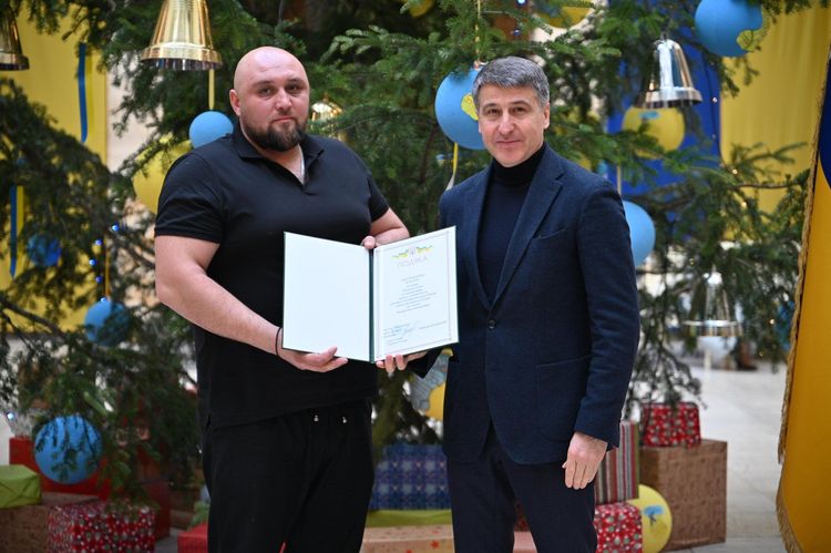 Мирослав Білецький вручає відзнаку волонтеру