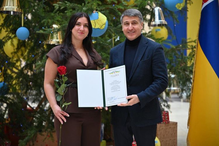 Мирослав Білецький вручає відзнаку волонтерці