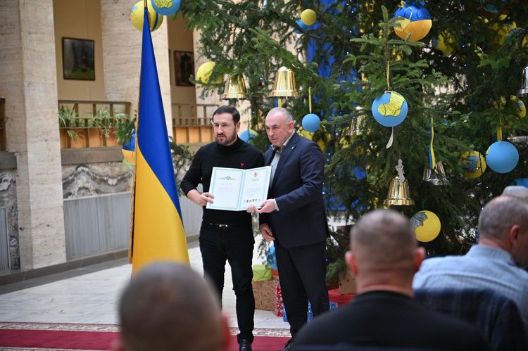 Заступник голови облради Василь Дем'янчук вручає відзнаку волонтеру