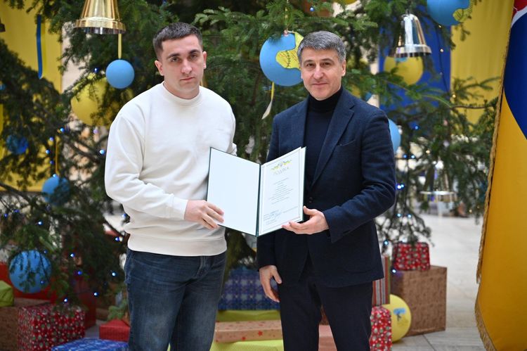 Мирослав Білецький вручає відзнаку волонтеру