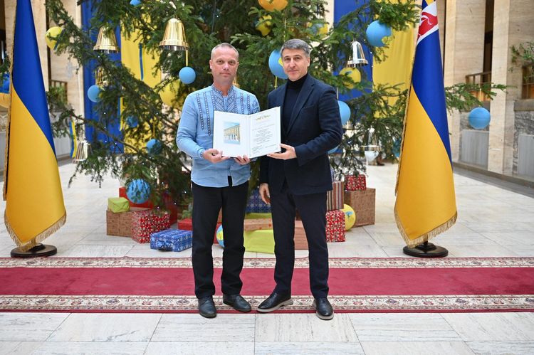Мирослав Білецький вручає відзнаку волонтеру