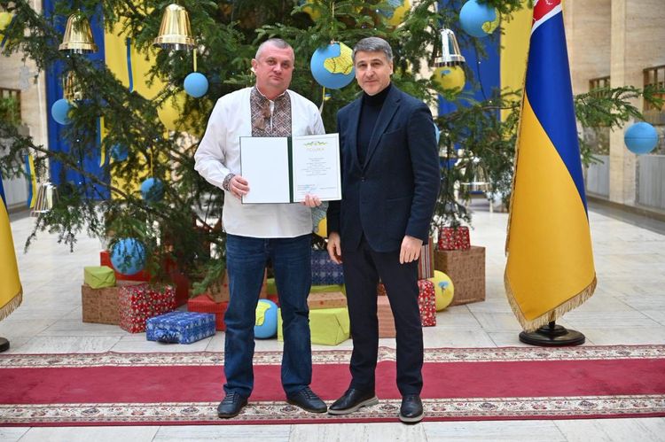 Мирослав Білецький вручає відзнаку волонтеру
