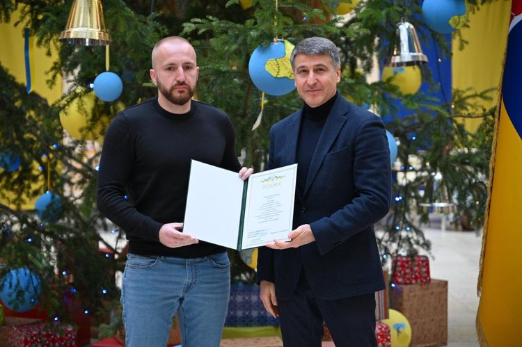 Мирослав Білецький вручає відзнаку волонтеру
