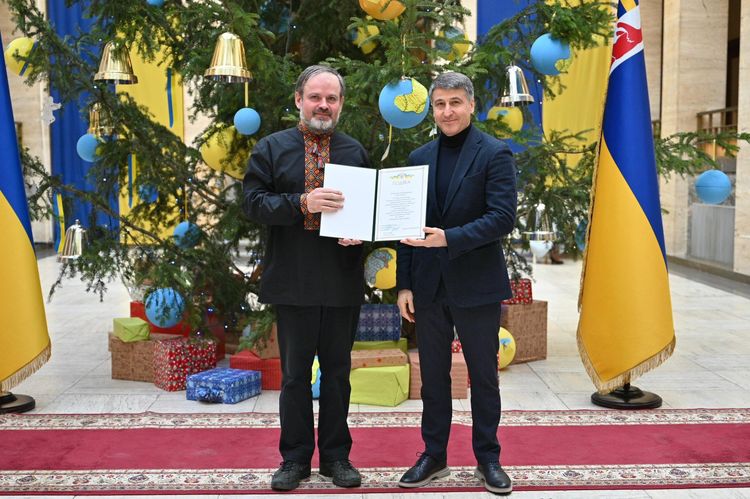 Мирослав Білецький вручає відзнаку волонтеру